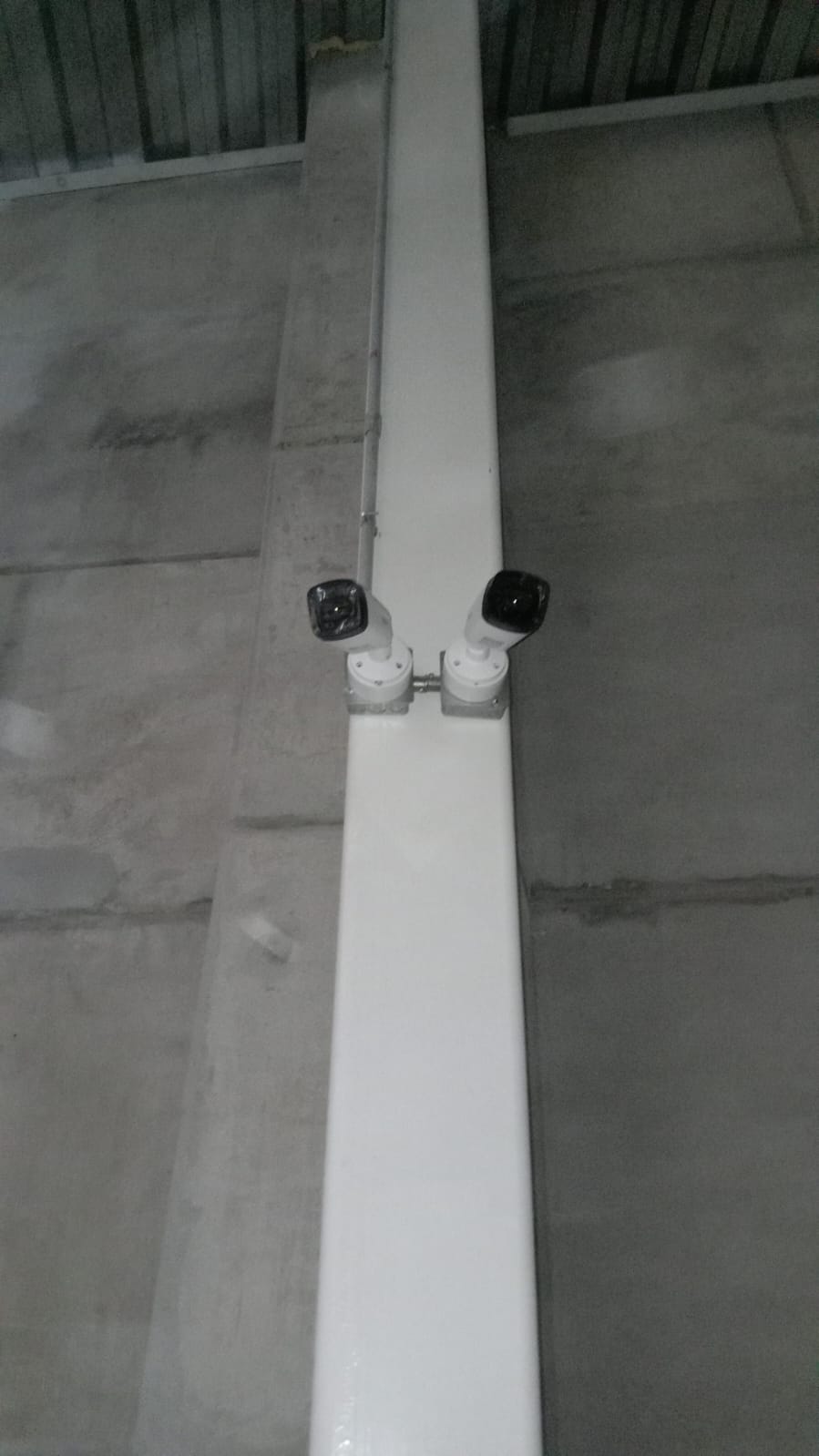 Dos cámaras montadas sobre una columna en un espacio industrial